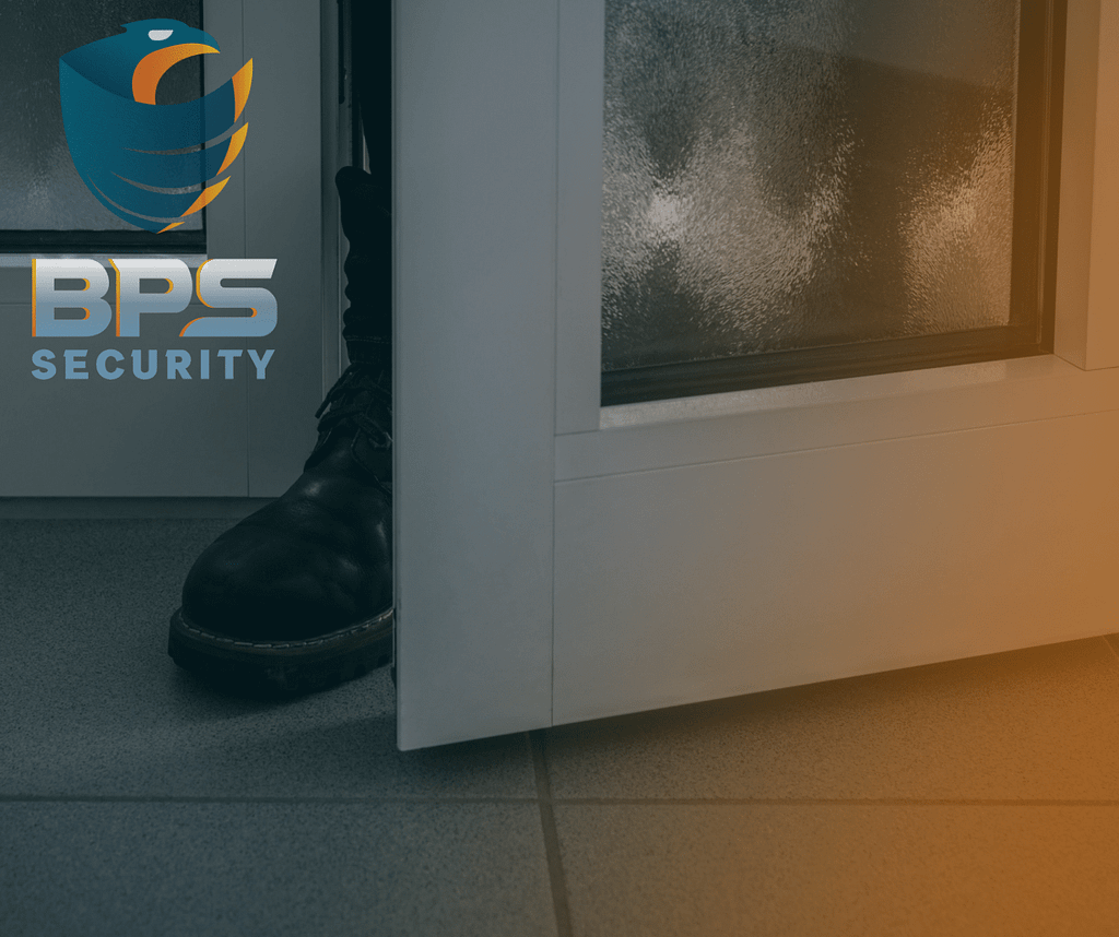 This image is an ominous photo where a burglar has his boot in the crack of the door . This image is included in the BPS Security article titled, “How to Stay Safe at Home: Tips for Property Crime Prevention”
