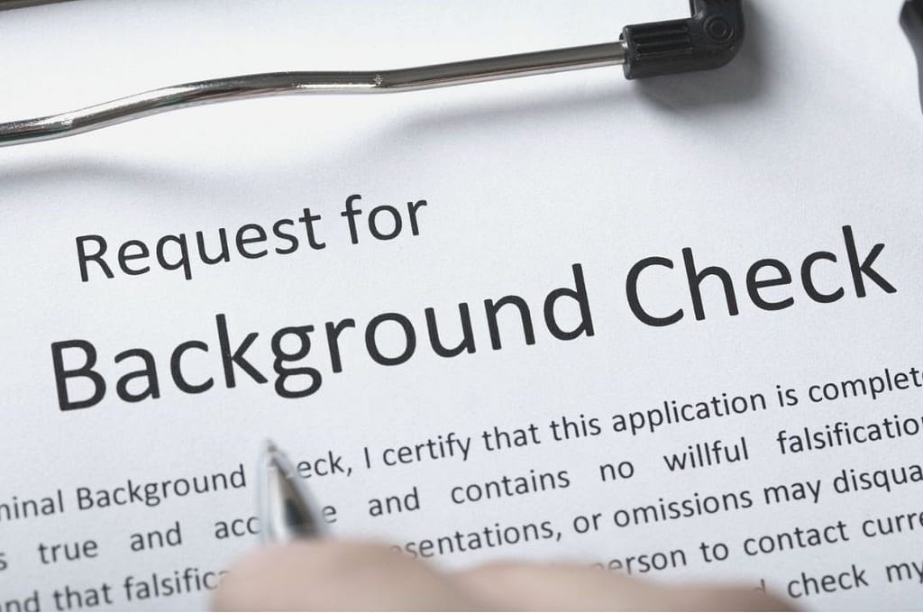 This is a closeup image of a clipboard holding a piece of paper that reads “request for background check”, with a paragraph explaining what the background check will consist of. This image is used in the BPS Security blog header image for the blog titled, “What Kind Of Background Check Will I Get When Applying to be a Security Guard?”