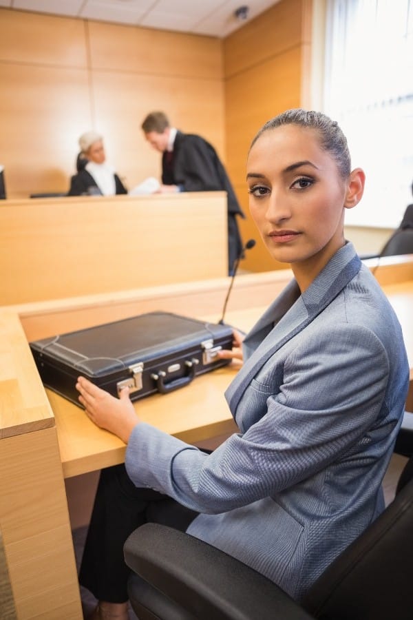 a lawyer in a courtroom looking back at the camera. Her briefcase contains the evidence gathered as a part of BPS Security's surveillance services