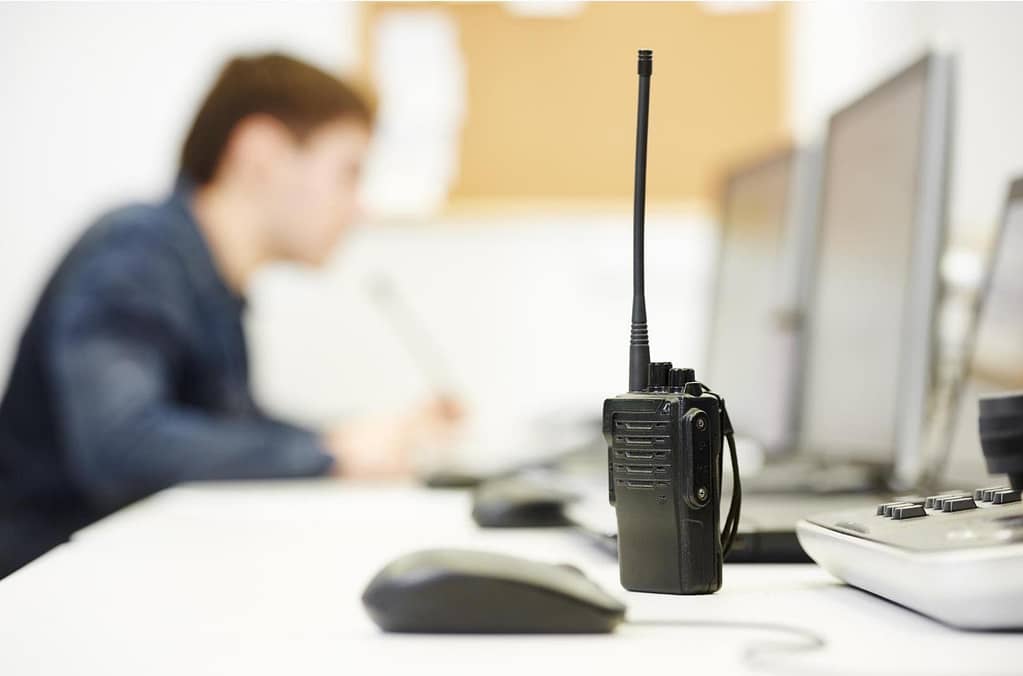 This image showcases a security guards walkie talkie, with the guard himself slightly blurred in the background. This image is used for the BPS Security article titled, “Why Hiring Private Security Is Essential - 4 Reasons Why”.