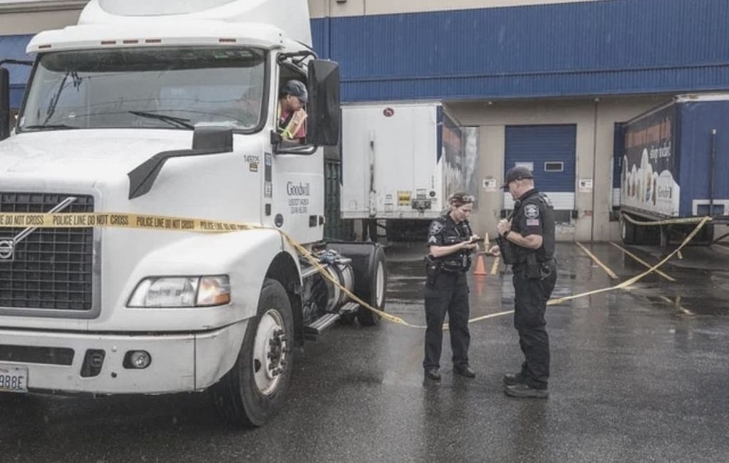 This image is of a crime scene at a loading dock. There is a large truck and two trailers (that are up against loading docks) and two police standing next to “crime scene” tape. This image is used in the San Antonio-based BPS Security article titled, “Are Your Loading Docks Safe?”