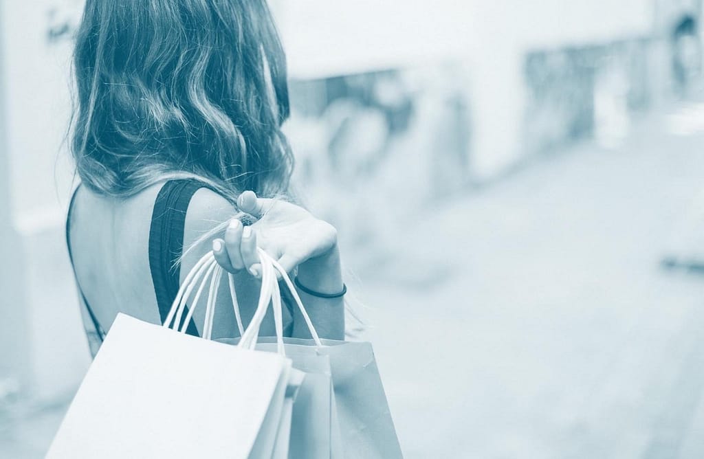 This is an image of a woman holding shopping bags over her shoulder and walking away from the camera. This image is used in the BPS Security article titled, “How Criminals Use Profiling in Loss Prevention to Their Advantage.”