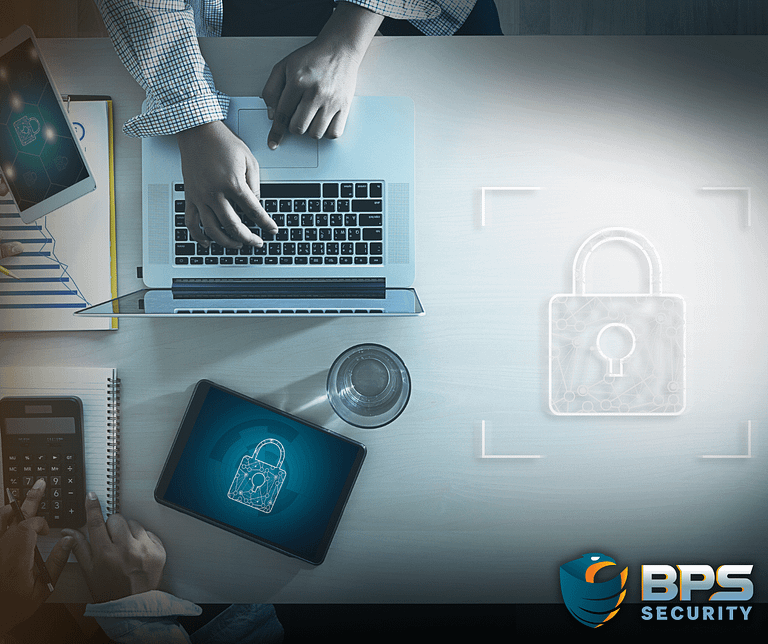 This image shows a table where people are working alongside technology with security padlock symbols on their screens. This is the supporter image used in the BPS Security blog titled, “Securing Your Business: Best Practices for Small Business Owners''